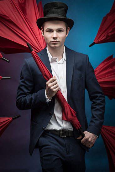 Künstler-Portrait-Foto des Zauberer Samuel Görss mit Zylinder und roten Regenschirmen